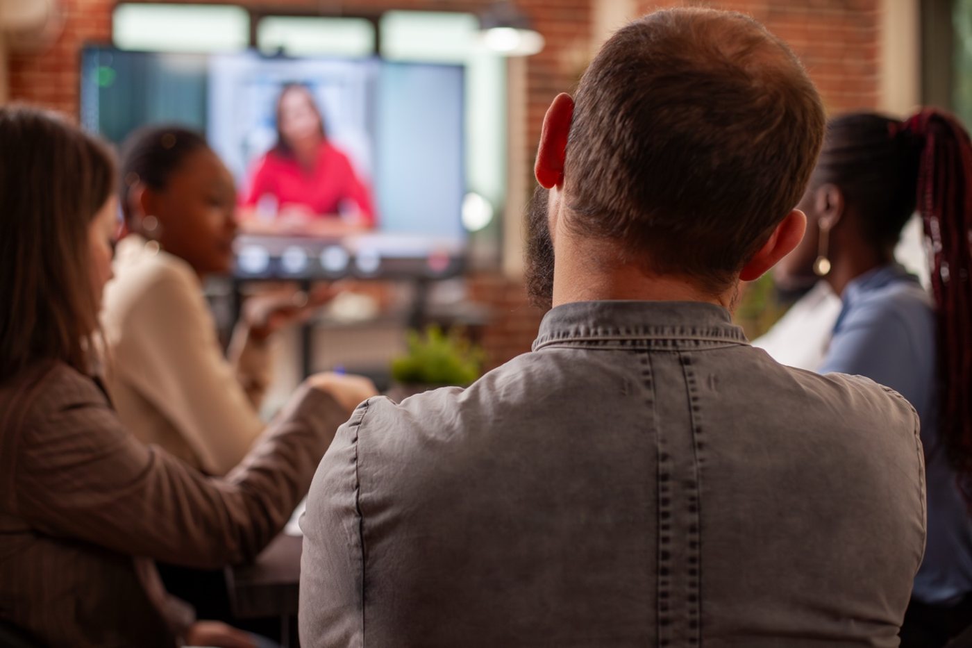 Audience watching a conversation on screen (editorial placeholder image)